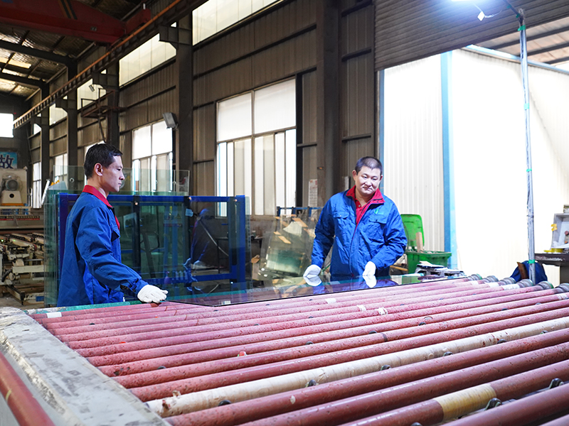 Опытная команда по производству архитектурного стекла работает на заводе